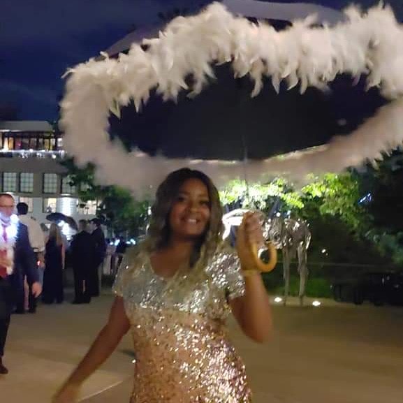 Second line performer with feathered umbrella